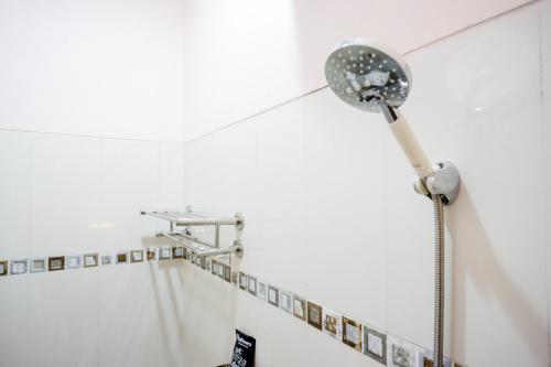 a shower head in a bathroom with a shower curtain at RedDoorz near Gejayan 3 in Yogyakarta