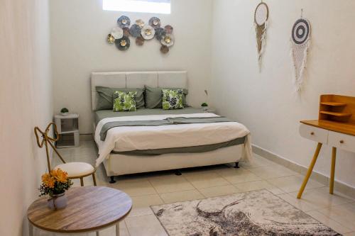 a bedroom with a bed and a table with plates on the wall at Charming 2BR Home Close to Pering Beach Gianyar in Saba