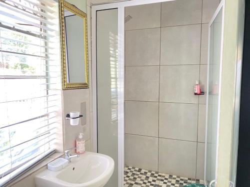 a bathroom with a sink and a shower at Stay Arcadia Guest House in Pretoria