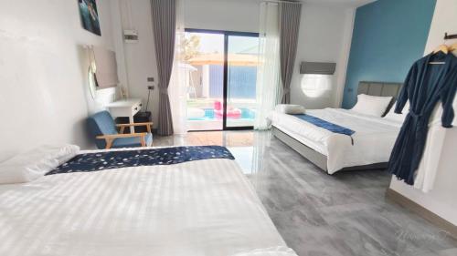 a hotel room with two beds and a balcony at บ้านออมPool villa บางแสน om in Ban Bang Saen (1)