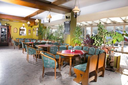 a restaurant with tables and chairs and plants at Wellness Hotel Astra in Špindlerův Mlýn