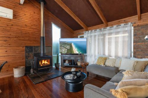 a living room with a couch and a fireplace at Hilltop Hideaway at Coolum Beach in Coolum Beach