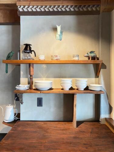 a shelf with plates and a kettle on it at ROHAUS Entire Home with private Hot Spring in Shiraoi