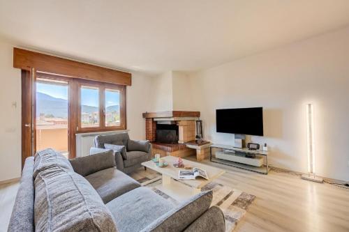 a living room with a couch and a tv at Casa Alexander - Lake Garda Apartment with Terrace - Happy Rentals in Riva del Garda