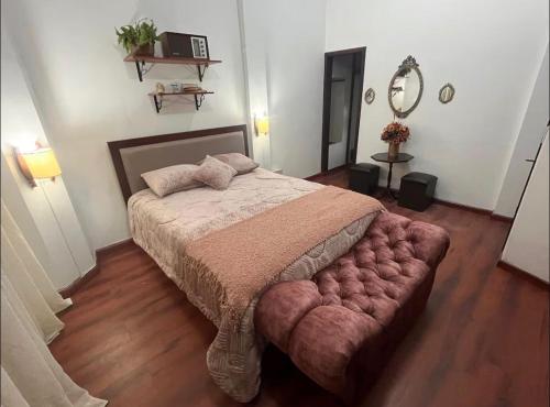 a bedroom with a large bed with a red tufted bedskirts at HABITACION MODERNA CON PARQUEO y WIFI in Ambato
