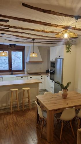 a kitchen with a wooden table and a table and chairs at Casa Rural Doña Aba in Espinosa de los Monteros