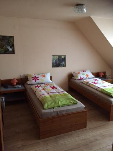 a bedroom with two beds with green sheets at Gasthof Hausmann in Schlüchtern