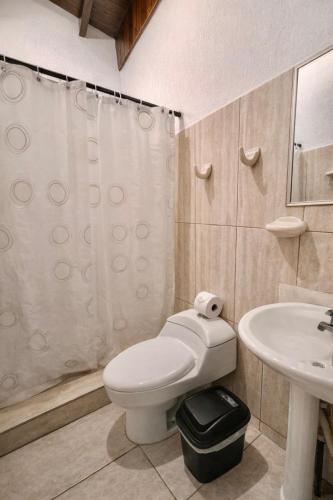 a bathroom with a toilet and a sink at Green Point Nosara in Nosara