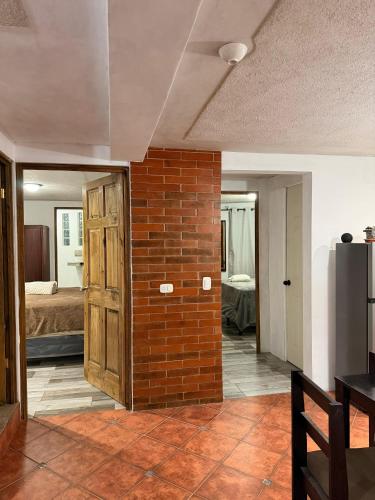 a brick wall in a room with a bedroom at Apartamento Xeul in Quetzaltenango