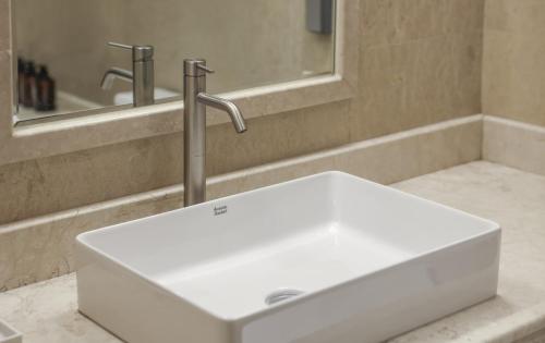 a white sink in a bathroom with a mirror at Kensington Hotel Yeouido in Seoul