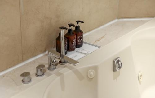 a bathroom sink with two shampoo bottles on it at Kensington Hotel Yeouido in Seoul