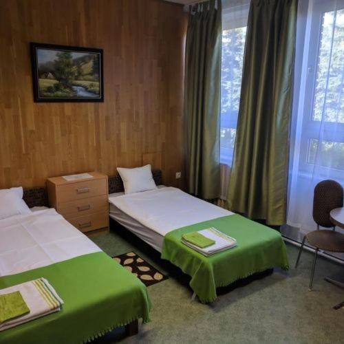 a hotel room with two beds and a window at Berek Szálló in Balatonfenyves
