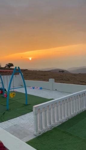 a view of a playground with the sunset in the background at إستراحة حجيف فيو in Salalah