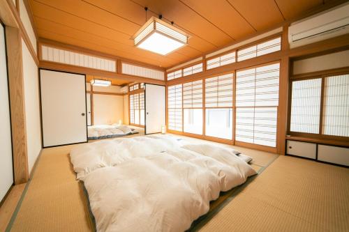 a large white bed in a room with windows at Morioka base モリオカベース in Morioka