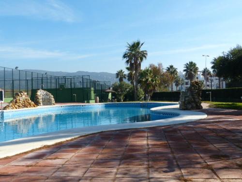 una piscina en un complejo con palmeras en Apartamento Atlanterra Sol, en Zahara de los Atunes