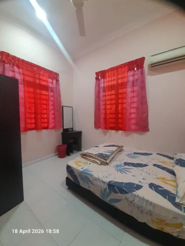 a bedroom with two red windows and a bed at Jaya's Homestay in Simpang Ampat