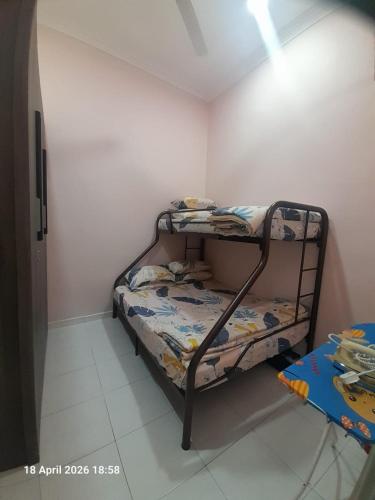 a bedroom with two bunk beds in a room at Jaya's Homestay in Simpang Ampat