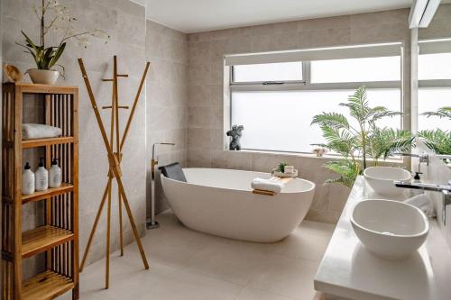 a bathroom with a large tub and a sink at Elevation in Bicheno