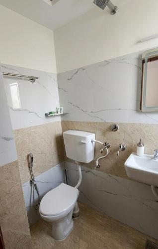 a bathroom with a toilet and a sink at Ebenezer Stay in Trivandrum