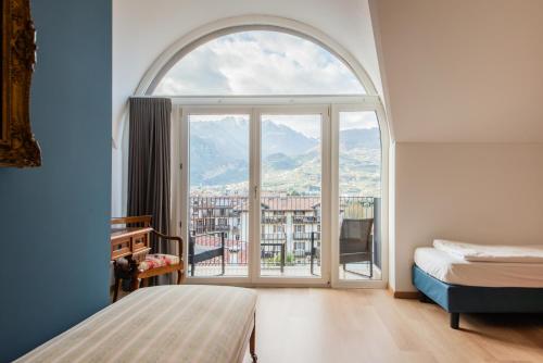 sypialnia z dużym oknem z widokiem w obiekcie Hotel San Giorgio w Arco