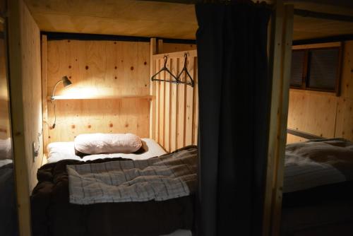 a bedroom with two beds in a room with wooden walls at Kagaribi Guesthouse in Tokyo