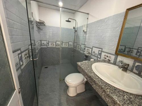 a bathroom with a toilet and a sink and a shower at VANDA Hotel Nha Trang in Nha Trang