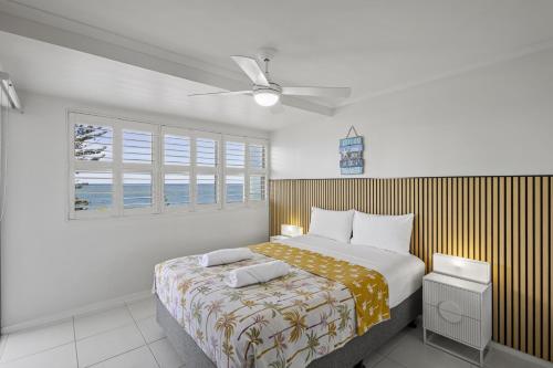 a bedroom with a large bed and a window at Malibu Apartments in Mooloolaba