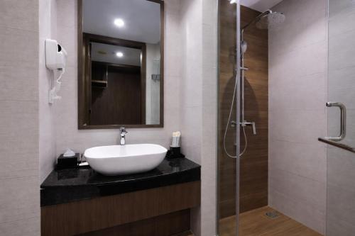 a bathroom with a sink and a shower at Harper Premier Nagoya Batam in Nagoya