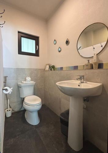 a bathroom with a sink and a toilet and a mirror at Emoha Dive Resort in Oslob