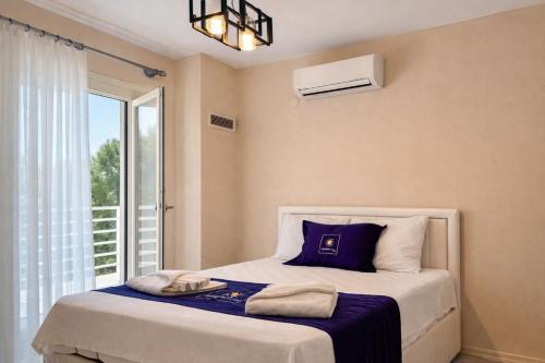 a bedroom with a bed with a blue pillow and a window at Villa Kumsal in Kuşadası
