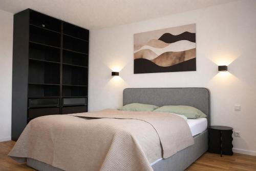 a bedroom with a bed and two lights on the wall at Ferienwohnung Südwind 2 in Hohentengen
