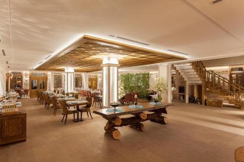 a dining room with tables and chairs and a staircase at Orchis Hotel in Ayvalık