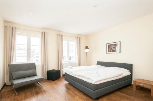 ein Schlafzimmer mit einem Bett und einem Stuhl in der Unterkunft Appartement "7up" contacless Check in in Hamburg