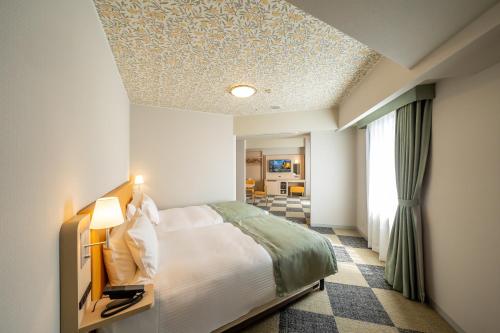 a bedroom with a bed and a coffered ceiling at Hotel Monterey La Soeur Naha in Naha