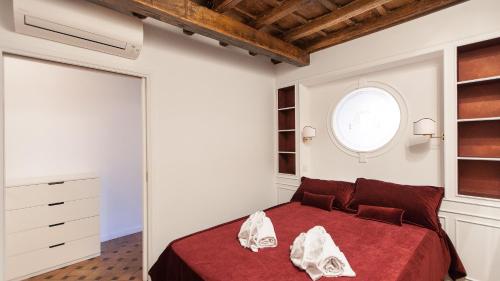 una camera da letto con un letto rosso e una finestra di Rental in Rome - Scala Suite a Roma