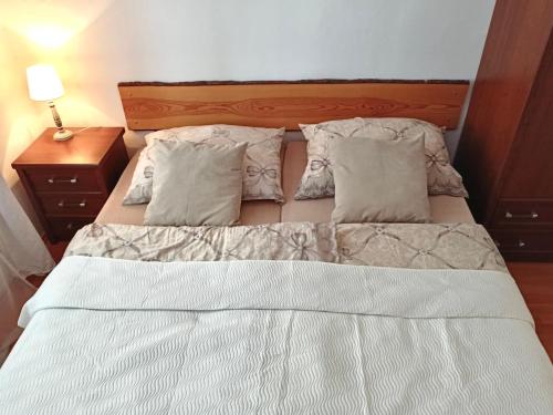 a bed with white sheets and pillows in a bedroom at Apartmán Simi, Karlovice 251, 79323 Karlovice in Karlovice