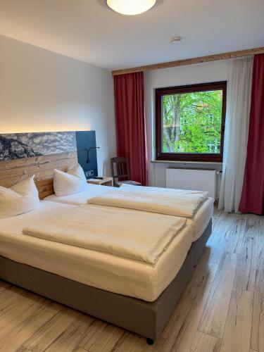a bedroom with two beds and a window at Hotel-Restaurant Dechbettener Hof in Regensburg