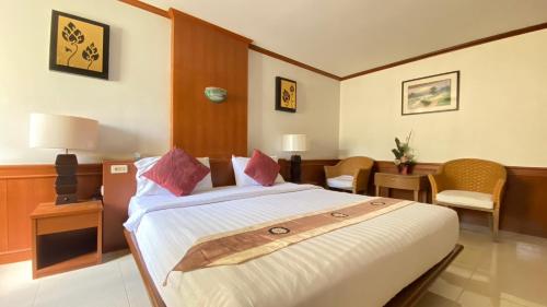 a hotel room with a large bed and chairs at โรงแรมสยามบูทีค บุรีรัมย์ in Buriram