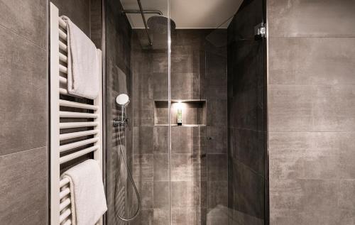a bathroom with a shower with a glass door at Hotel Isartor in Munich