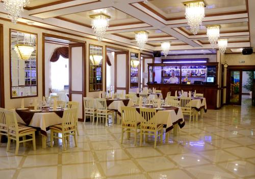 a dining room with tables and chairs and a television at BeSt Hotel and Restaurant complex in Dunaivtsi