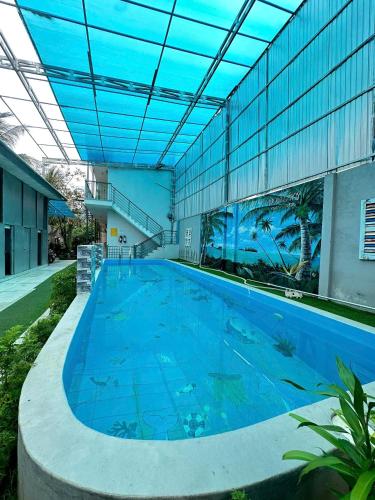 a large swimming pool in front of a building at Homestay canthoriver in Ấp Bình Lạc