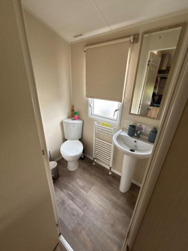 a small bathroom with a toilet and a sink at Seaside Lodge Haven in St Osyth in Jaywick Sands