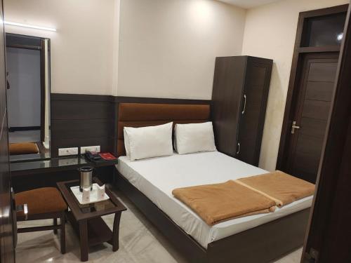 a small bedroom with a bed and a table at Hotel Tara Palace, Chandni Chowk in New Delhi