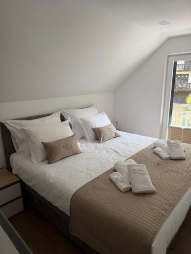 a large white bed with two pillows on it at Apartments CRYSTAL AURA in Bohinj