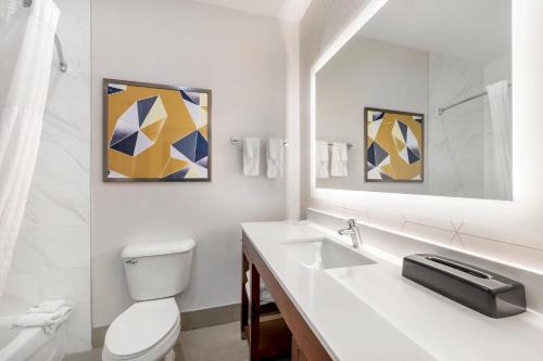 a white bathroom with a toilet and a sink at Comfort Suites Fort Wayne North in Fort Wayne