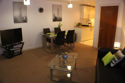 a living room with a table and chairs and a kitchen at Marina Water View Apartment in Hull