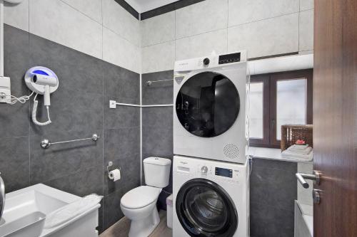 a bathroom with a washer and a washing machine in it at Casa da Ponte in Lombinha