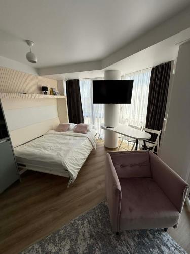a bedroom with a bed and a desk and a chair at Breeze Studio in Palanga