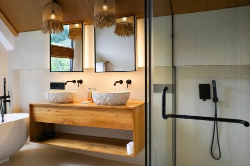 a bathroom with two sinks and a shower at Dzen Greenfield Villa 6 in Ubud