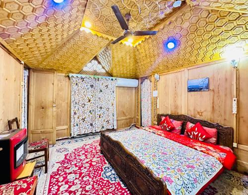 a bedroom with a bed and a ceiling fan at Houseboat New world in Srinagar